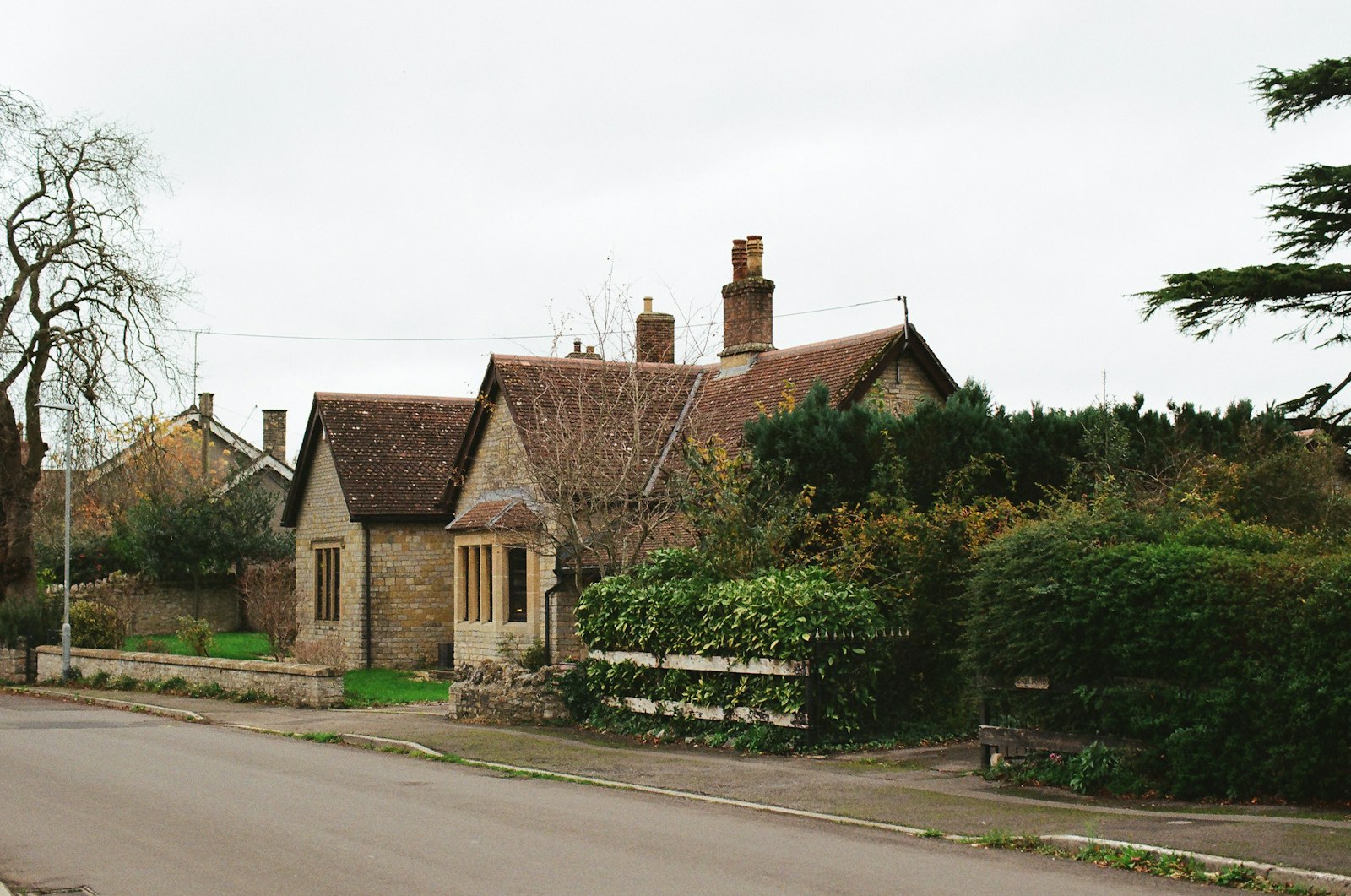 A traditional English stone cottage with a tiled roof and garden